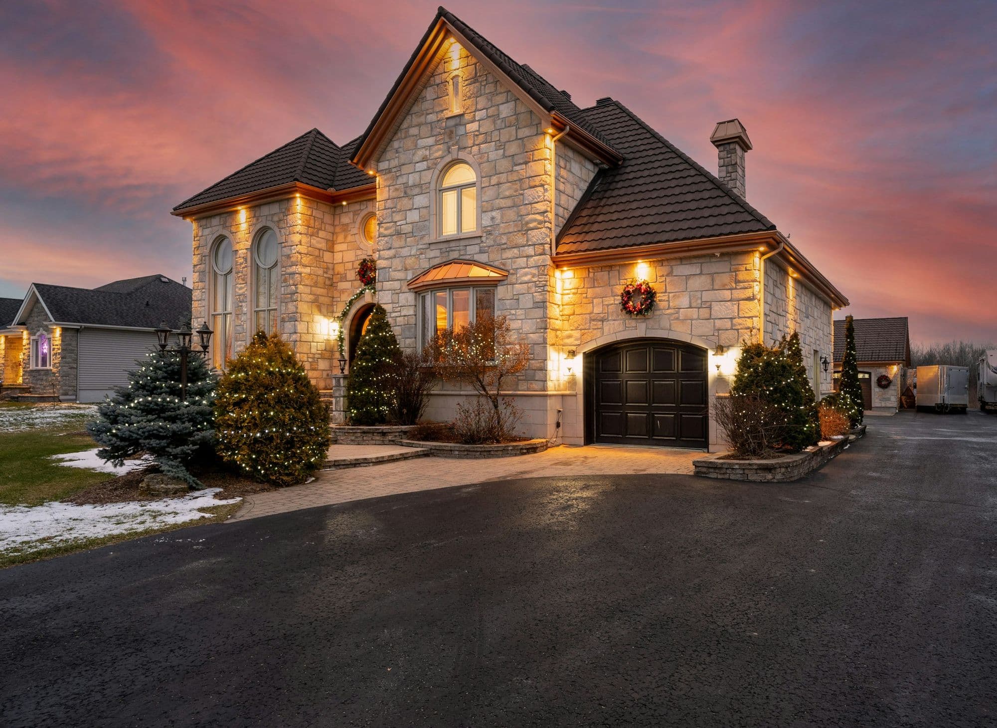 Stone home with warm lights glowing at dusk