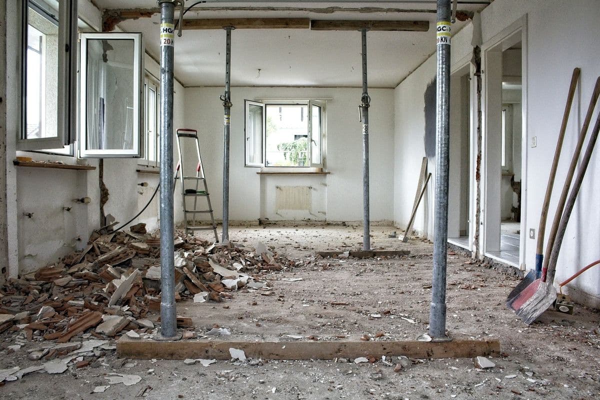 Room mid-renovation with walls opened up and tools on the floor