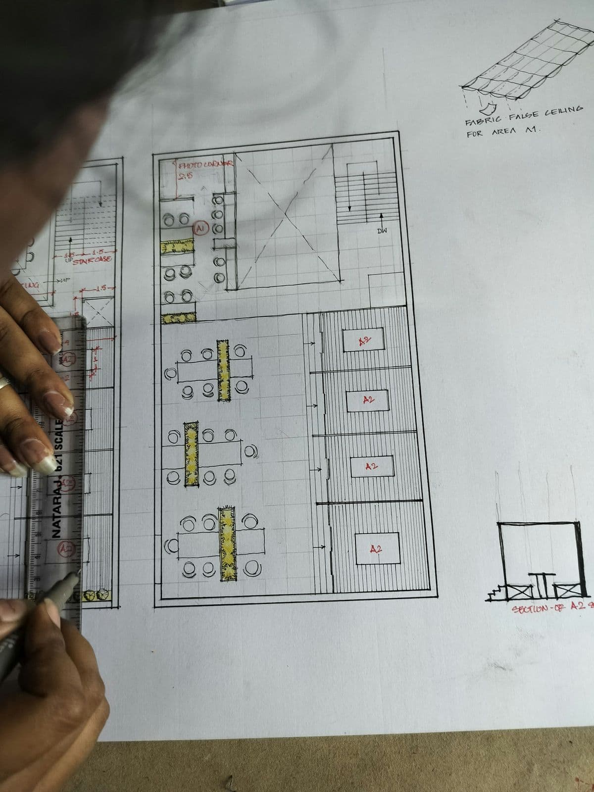Hand sketching a floor plan in pencil on paper